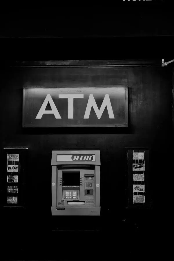 Caixa eletrônico da ATM. Foto em preto e branco.