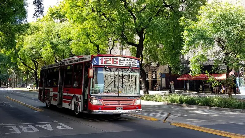 Ônibus vermelho circulando pelas ruas de Buenos Aires na Argentina durante o dia